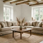 Salon scandinave décoré avec sobriété, canapé en lin beige, table basse en noyer et herbes de pampa séchées dans un vase céramique