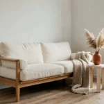 Salon scandinave avec canapé en bouclé ivoire, table en travertin et vase en terre cuite avec herbes de la pampa, tendances déco intérieur